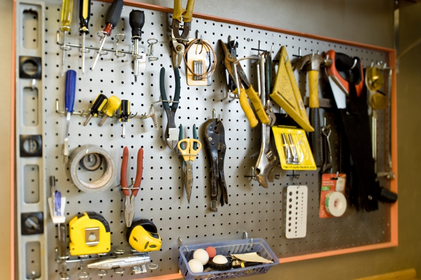 Old claw hammer hanging on yellow peg board